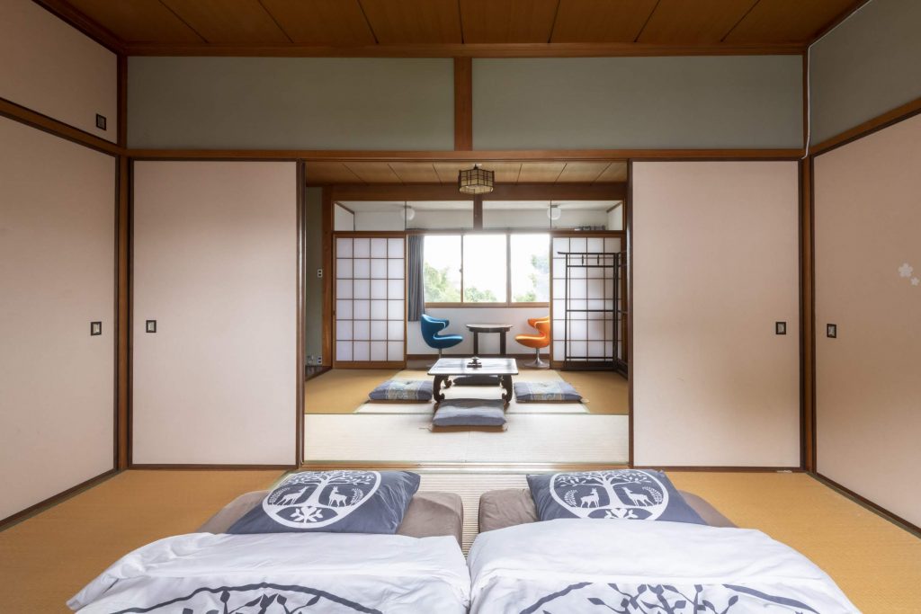 Picture of a beautiful guesthouse room in Nara featuring tatami rooms, inviting futons, captivating pop-art elements, and traditional art.